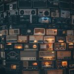 a large amount of old radio's stacked on top of each other