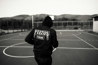 man in black and white hoodie standing on track field