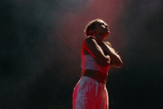 Artistic expression through dance captured in dramatic lighting on a dark stage.