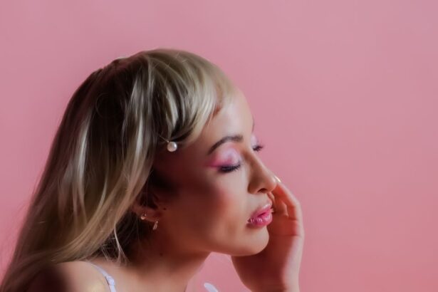 Portrait of a woman showcasing elegant beauty against a pastel pink background.