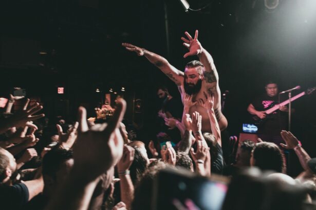 Dynamic image of a musician crowd surfing at a lively concert with enthusiastic audience interaction.