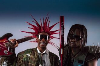 Two adults in punk rock attire with eccentric hairstyles and accessories showcasing edgy style.