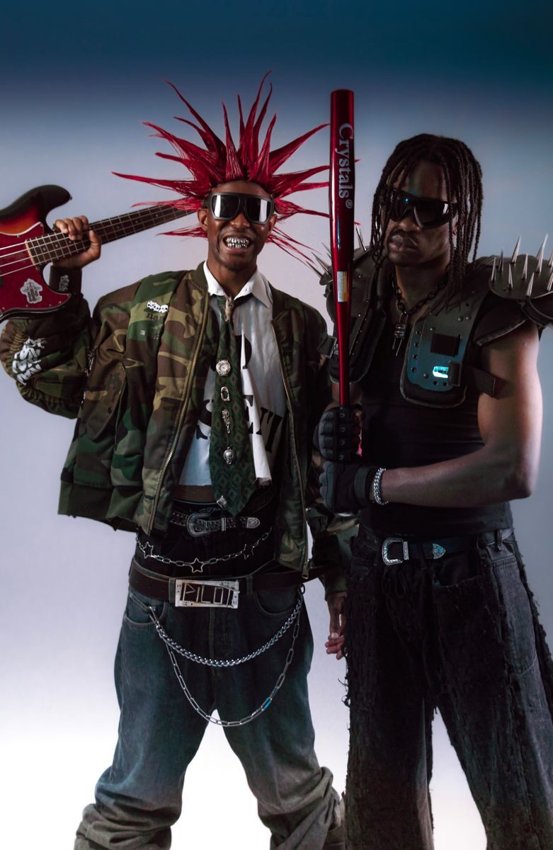 Two adults in punk rock attire with eccentric hairstyles and accessories showcasing edgy style.